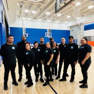 School cleaning team on site cleaning sports floor at university