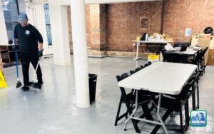 Cleaner sweeping and cleaning concrete floor in office space