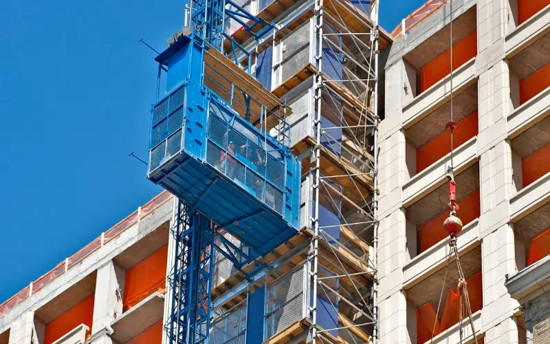 Construction workers taking the elevator in Manhattan high-rise under construction