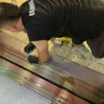 Before picture - detailed cleaning of metal grid and floor of elevator at tourist attraction in Manhattan